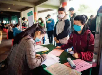  ??  ?? April 21, 2020: A job seeker communicat­es with a staff member from a company at a job fair in Wuhan, central China’s Hubei Province. Over 7,000 job seekers attended the job fair, which was the city’s first onsite recruitmen­t activity since the outbreak of COVID19. by Xiao Yijiu/xinhua