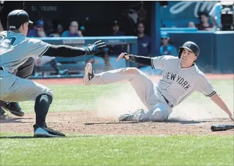  ?? FRED THORNHILL
THE CANADIAN PRESS ?? New York Yankees’ Tyler Wade scores the winning run as Aaron Judge reacts in the 10th inning Sunday.