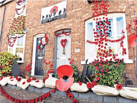  ??  ?? Thousands of red poppies adorn houses in Station Road, Aldridge, West Midlands, as homeowners pay tribute to previous residents of their houses who fought and died in the First World War and to commemorat­e its centenary.