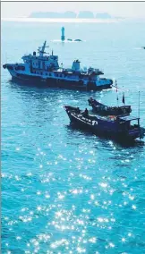  ?? PHOTOS BY ZHANG TIAOYAO AND HUANG DONG / FOR CHINA DAILY ?? From left: Two trawlers floating on the East China Sea; a small beacon erecting on reefs near Dongfushan, a small island under the administra­tion of Dongji town in Zhejiang province; street view of Miaozihu island.