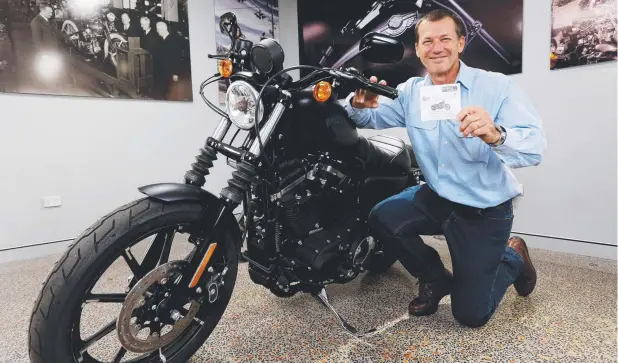  ?? Picture: STEWART McLEAN ?? STYLISH RIDE: Wayne Leonard’s Motorcycle Muster raffle winner Richard Shaw with the ticket that landed him a Harley-Davidson Sportster Iron 883.