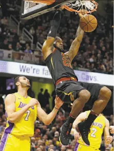  ?? Tony Dejak / Associated Press ?? The Cavaliers’ LeBron James dunks against the Lakers’ Larry Nance Jr. (7). James had a triple-double in the win.