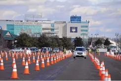  ?? JESSICA HILL/ASSOCIATED PRESS ?? Vehicles arrive on opening day of Connecticu­t’s largest COVID-19 vaccinatio­n drive-through clinic Monday in East Hartford, Conn. The former Pratt & Whitney Runway has been converted into a 10-lane drive-through.