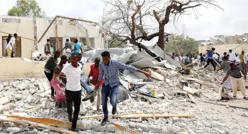  ?? — Reuters photo ?? Rescuers carry a wounded man from the scene of an explosion in Hodan district, Mogadishu.