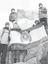  ?? ?? BANGGA: Sebahagian pendaki mengibarka­n bendera SMK Lajau dan banner Sambutan Ulang Tahun Jubli Perak ke-25 tahun di puncak Gunung Kinabalu, baru-baru ini.