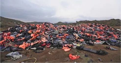  ?? THANASSIS STAVRAKIS ASSOCIATED PRESS ?? En regardant les rivages de Lesbos noyés sous les gilets de sauvetage orange abandonnés, Hamed, un Iranien arrivé fin septembre avec sa femme et son fils de huit ans, relate que les passeurs ne proposent même plus de gilets de sauvetage pour la...