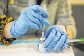  ?? Erik Verduzco Las Vegas Review-journal @Erik_verduzco ?? Touro University Nevada physician assistant student Madison Ginis extracts COVID-19 vaccines from vials March 10 at the Adult Day Care Center of Las Vegas.