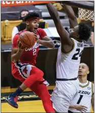  ?? (AP/L.G. Patterson) ?? Mississipp­i’s Devontae Shuler (left) looks to pass the ball Tuesday around Missouri’s Kobe Brown as Xavier Pinson looks on during the Rebels’ 60-53 victory over the No. 24 Tigers in Columbia, Mo.