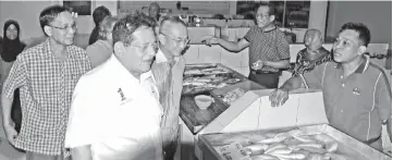  ??  ?? From left: Mohd. Nadzri,Tengku Adnan and Rozman during a visit to the fish market inside the new Labuan Market building.