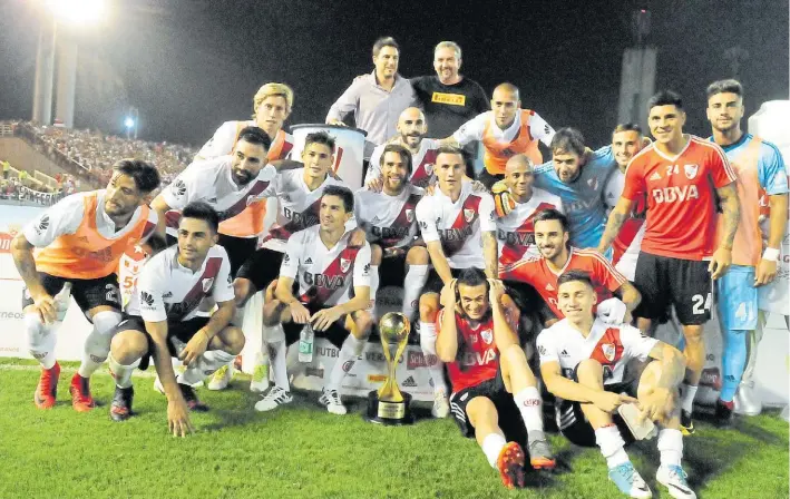  ??  ?? La copa del verano. Borré, con camiseta roja, posa al lado del trofeo. Su gol decidió un clásico deslucido, en el que River hizo un poco más que Boca.