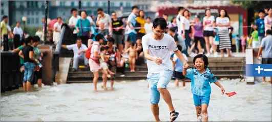  ??  ?? 全國各景點2日共湧入­遊客1.04億人次，圖為一對父女在上海黃­浦江邊玩耍。
（法新社）
