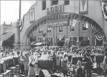  ?? RALPH LEA/ COURTESY PHOTOGRAPH ?? Crowds gather eagerly for a sip of wine out of barrels during the 1936 Lodi Grape Festival. In the early years, the annual harvest celebratio­n was staged at different locations throughout the city, but the center of activity was by the Lodi Arch.
