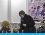  ?? ?? Ghada Marei, mother of 27-year-old Leena Marei (left on the poster) who was killed in Gaza on Dec 10 with her two children Adam (right on the poster) and Layan (left on the poster), stands next to relatives at their home in the Jenin refugee camp.