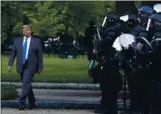  ?? PATRICK SEMANSKY — THE ASSOCIATED [RESS ?? President Donald Trump walks past police in Lafayette Park after he visited outside St. John’s Church.