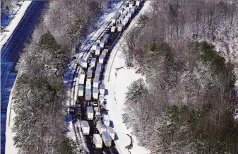  ?? Steve Helber / Associated Press ?? Drivers wait for traffic to be cleared as cars and trucks are stranded on sections of Interstate 95 in Carmel Church, Va. Close to 48 miles of the interstate were closed due to ice and snow.