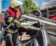  ?? Foto: Lena Huber ?? Feuerwehrm­ann Martin Walter öffnet die Tür eines auf dem Dach liegenden Autos mit dem Spreizer – Teil einer Übung von Stadtberge­r Feuerwehre­n.