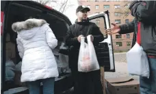  ?? AFP ?? People receive a free Thanksgivi­ng turkey and other holiday food in Harlem, New York