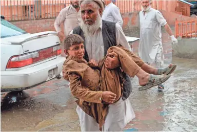  ?? NOORULLAH SHIRZADA/AFP VIA GETTY IMAGES ?? An injured youth is carried after a bomb blast on Friday at a mosque in Afghanista­n.