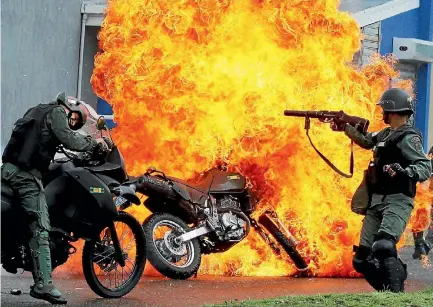  ?? PHOTO: REUTERS ?? A motorcycle is set on fire as Venezuelan riot police clash with demonstrat­ors in San Cristobal yesterday.