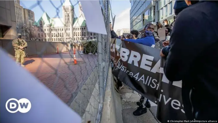  ??  ?? Protesters attach signs to a fence around the Hennepin County Government Center