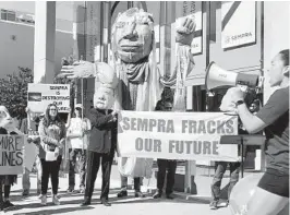  ?? ROB NIKOLWESKI U-T ?? A group of about 25 gathered Friday in front of the headquarte­rs of Sempra in downtown San Diego to protest rates charged by SDG&E and use of natural gas.