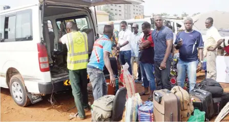  ??  ?? People wait to board a bus to travel for the Christmas holiday at Jabi Park in Abuja