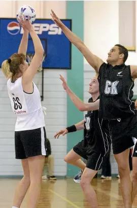  ?? STUFF ?? It’s not uncommon for the Silver Ferns to take on a men’s netball team. This photo from 2001 shows then star shooter Irene van Dyk lining up a shot against male opponents.