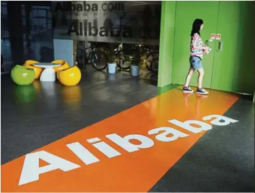  ?? — AFP ?? Hidden gem: An Alibaba employee walks through a communal space at the company’s headquarte­rs in Hangzhou. Largely ignored by analysts, Alibaba’s health unit suddenly soared in two weeks to reach a market value of US$8.7bil.