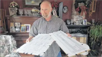  ??  ?? Robert Thurber with grave records of the Brookside Cemetery in Freeport, Digby County.