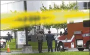  ?? MARK MAKELA / GETTY IMAGES ?? Police officers gather in front of a Rite Aid distributi­on center where four people were killed in a shooting Thursday in Aberdeen, Md. A woman opened fire at the business, killing three then herself.