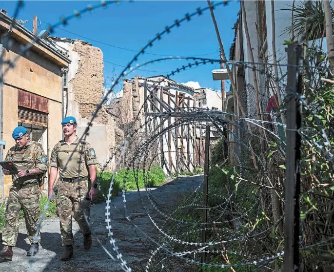  ?? —afp ?? Members of unficyp patrolling along the buffer zone. eu member Cyprus has been divided since 1974 when Turkyish forces occupied the island’s northern third in response to a military coup sponsored by the junta then in power in Greece.