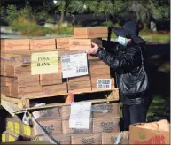  ?? ?? Volunteer Anita McKean, of Ridgefield, unstacks boxes containing bags of rice at St. Andrew's Church.