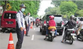  ?? ARISKI PRASETYO/JAWA POS ?? PERTAHANKA­N PARKIR SATU SAF: Petugas dishub mengatur kendaraan di kawasan kompleks SDN Pucang kemarin.