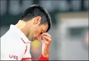  ?? Anne-christine Poujoulat / Getty Images ?? Novak Djokovic wears athletic tape on his neck during his match with Pablo Carreño Busta on Wednesday at the French Open in Paris.