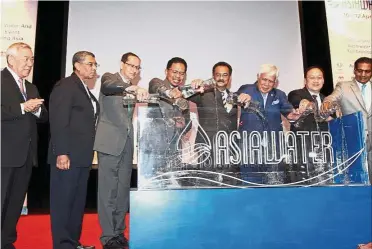  ??  ?? What an opening: Devamany (fifth from left), Zaini (fourth from left), UBM Malaysia co-chairman Tan Sri Mohd Azumi Mohamed (third from right) and other VIPs pouring water into a large tank at the official opening of AsiaWater 2018 at KLCC.