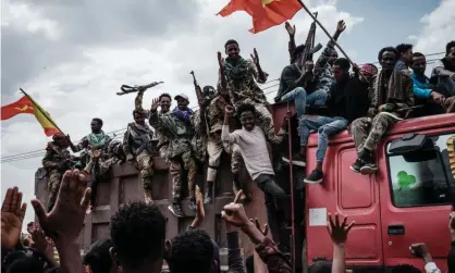  ?? Photograph: Yasuyoshi Chiba/AFP/Getty Images ?? Tigray People's Liberation Front (TPLF) fighters react to people from a truck as they arrive inMekele, the capital of Tigray region, Ethiopia in July 2021. The war broke out in November 2020.