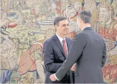  ?? REUTERS ?? Spain’s new Prime Minister Pedro Sanchez shakes hands with Spain’s King Felipe VI during a swearing-in ceremony near Madrid on Saturday.