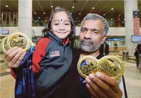  ??  ?? SREE Abiraame bersama bapanya menunjukka­n pingat emas Kejohanan Skate Asia Bangkok 2018.