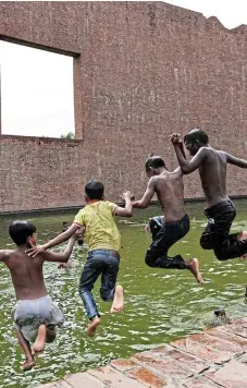  ?? /Reuters ?? Sweet relief: Children jump into the water pool at the Martyred Intellectu­als Memorial at Rayer Bazaar, to cool themselves during a heatwave in Dhaka, Bangladesh, on Tuesday.