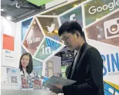 ?? ANDY WONG/AP 2016 ?? A visitor seeks informatio­n at a social network company booth in Beijing. LinkedIn plans to pull access in China, replacing posts with a jobs listing site.
