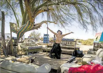  ?? Photograph­s by Allen J. Schaben Los Angeles Times ?? ARTIST Peter Passalacqu­a, 51, spins on a pole on the dance f loor of his open studio in Slab City. “We don’t wear masks,” he says. “We share the same marijuana pipe. We don’t wash the shot glasses at the local bar.”