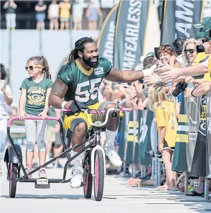  ??  ?? The Packers’ Za’Darius Smith rides a bicycle to the training camp in Green Bay.