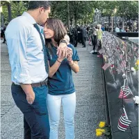  ?? GETTY IMAGES ?? Katie Mascali is comforted by her fiance, Andre Jabban, near the name of her father, Joseph Mascali, at the National September 11 Memorial & Museum in New York.