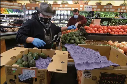  ?? PHOTOS BY ALAN DEP — MARIN INDEPENDEN­T JOURNAL ?? Produce clerk Francisco Ramirez restocks produce at Good Earth Natural Foods in Mill Valley on Friday.