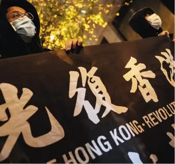  ??  ?? Le 26 avril dans les rues de Hongkong, des opposants se dissimulen­t le visage à l’aide de masques contre le coronaviru­s.