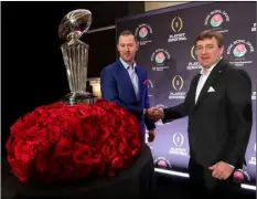  ??  ?? Oklahoma head coach Lincoln Riley (left) and Georgia head coach Kirby Smart shake hands next to the Rose Bowl trophy at the conclusion of a news conference with the two coaches Sunday in Los Angeles. Oklahoma and Georgia meet at the Rose Bowl in a...