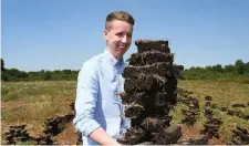  ??  ?? Our reporter Ryan Nugent with the dried turf from the Gilsenan family plot in Co Westmeath. Photo: Frank McGrath