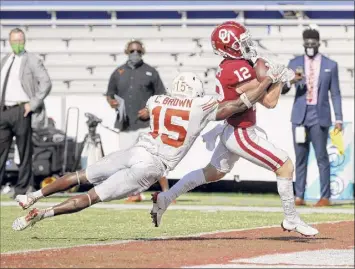  ?? Michael Ainsworth / Associated Press ?? Oklahoma wide receiver Drake Stoops scores the winning touchdown in the fourth overtime as Texas defensive back Chris Brown tries to tackle him during their game on Saturday.