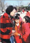  ??  ?? Zhang Shuqin (left), the founder of Sun Village, talks with the children of inmates.