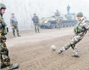  ?? FOTO: AFP ?? Soldados ucranianos juegan fútbol en una calle, ayer, en Svitlodars­k, cerca de Debaltseve.